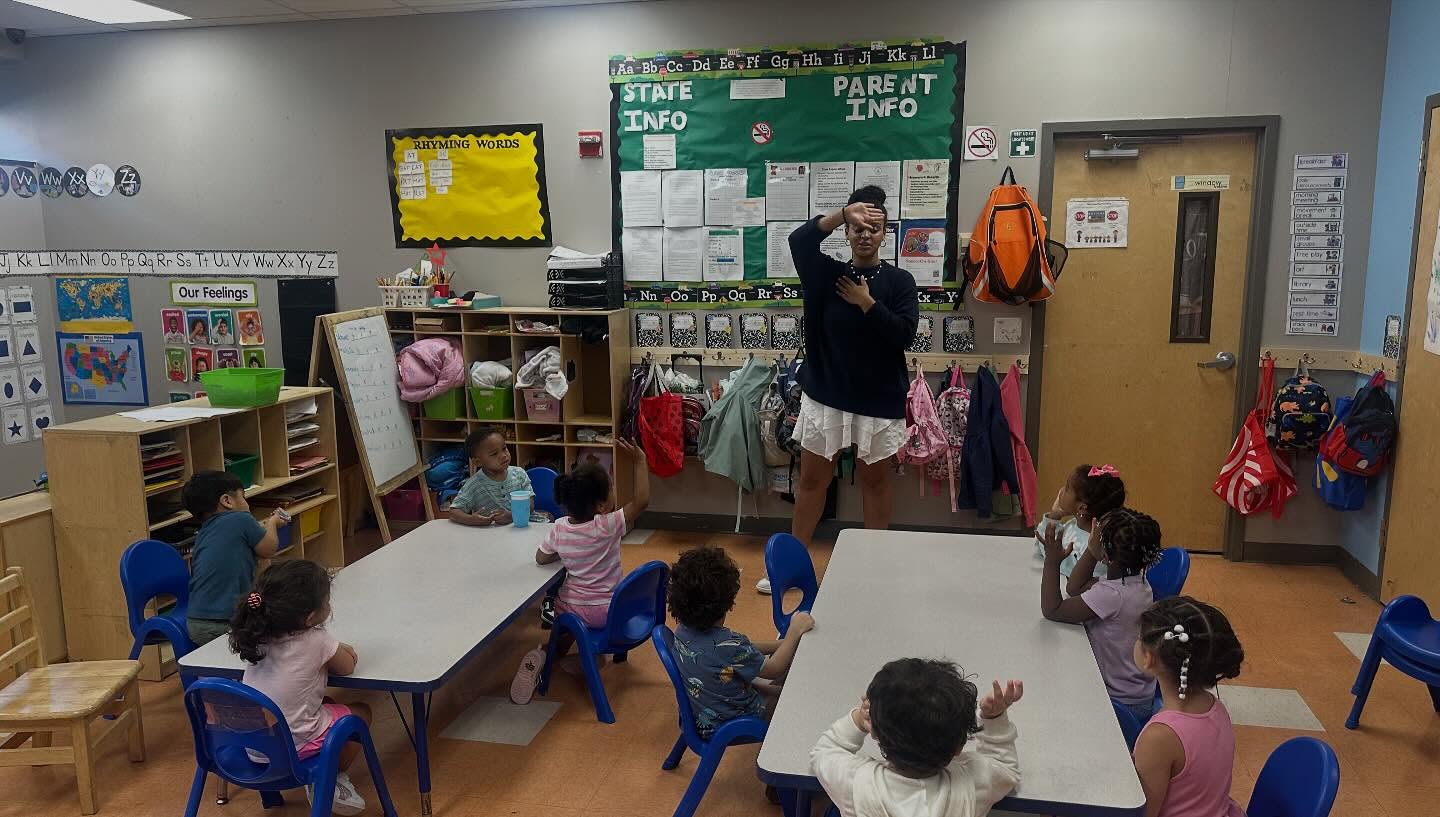 Photo of a classroom with a teacher and young children